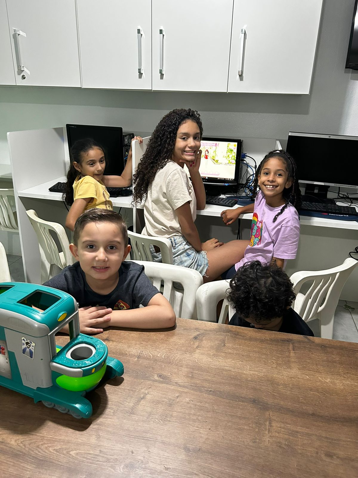 Crianças aprendendo com computadores no ministério