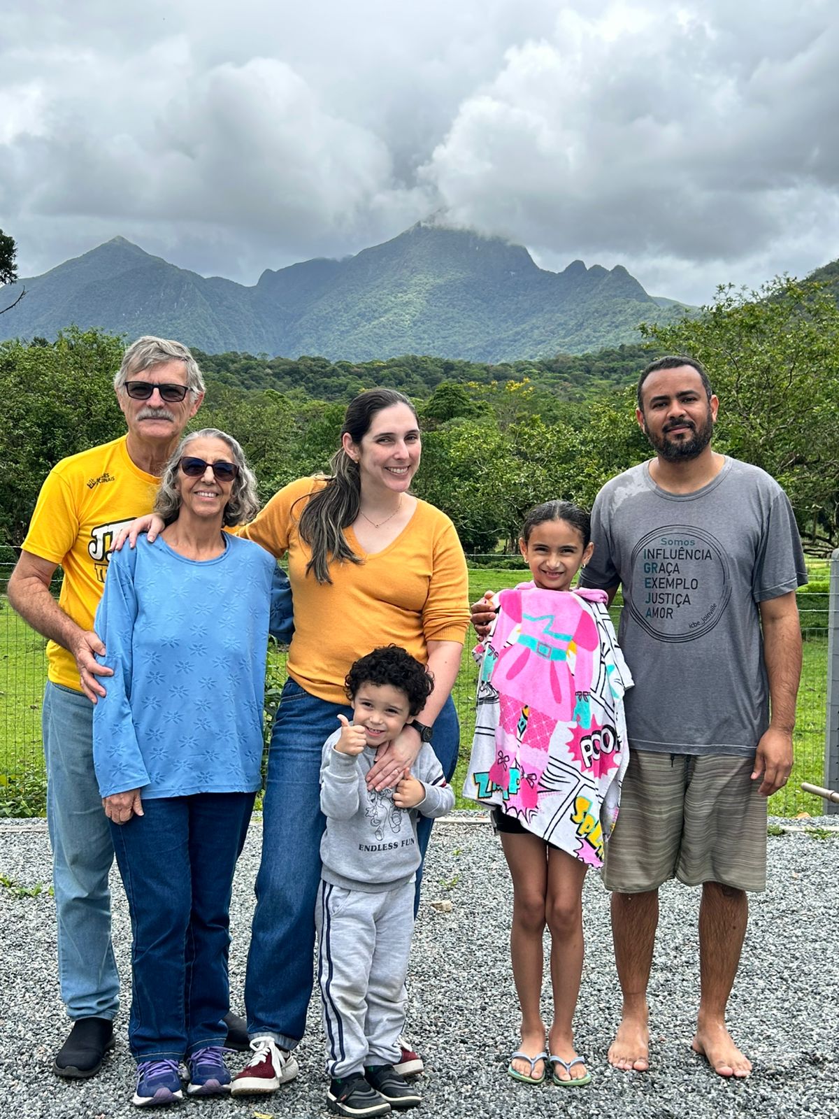 Família reunida após batismo com montanhas ao fundo